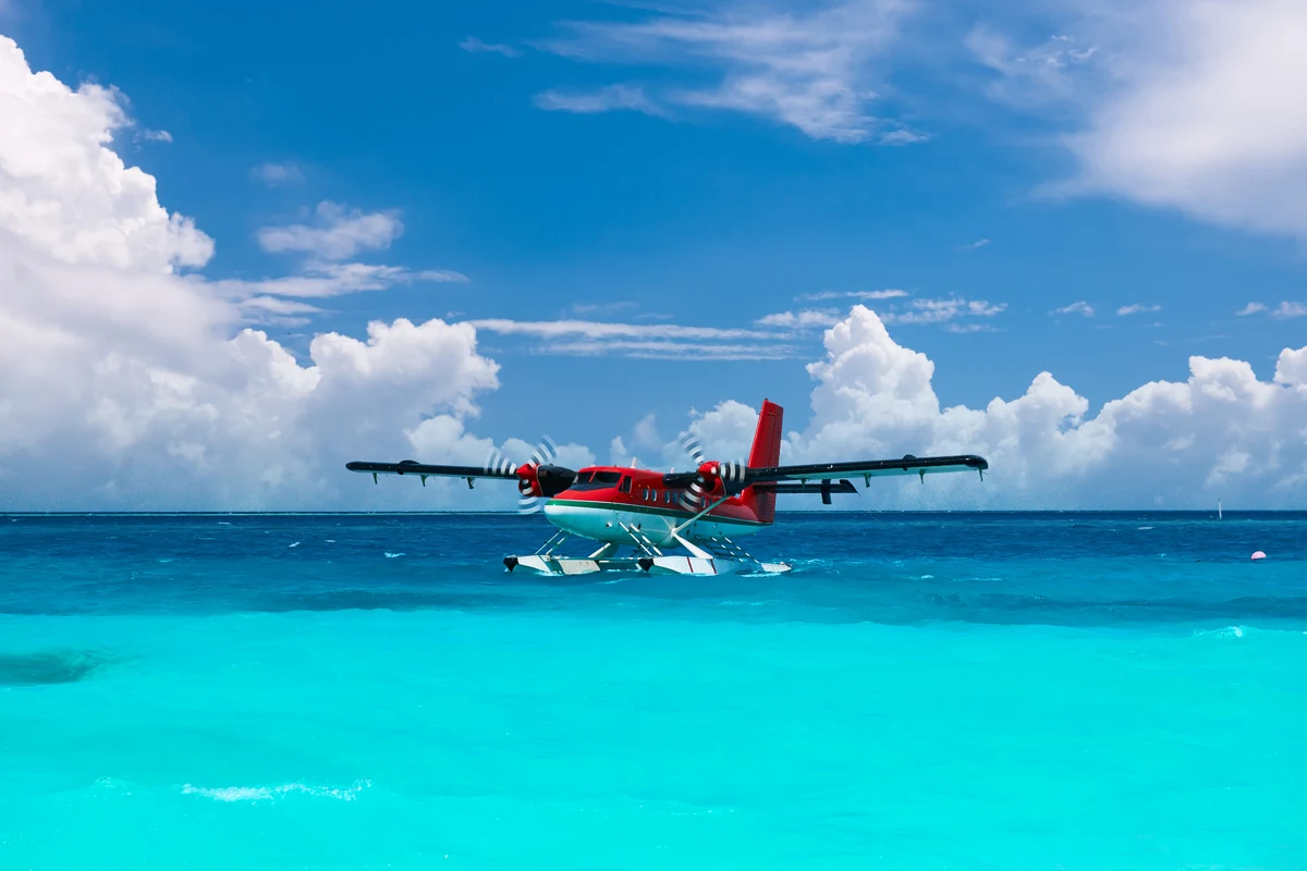 A seaplane on turquoise water in the Maldives.