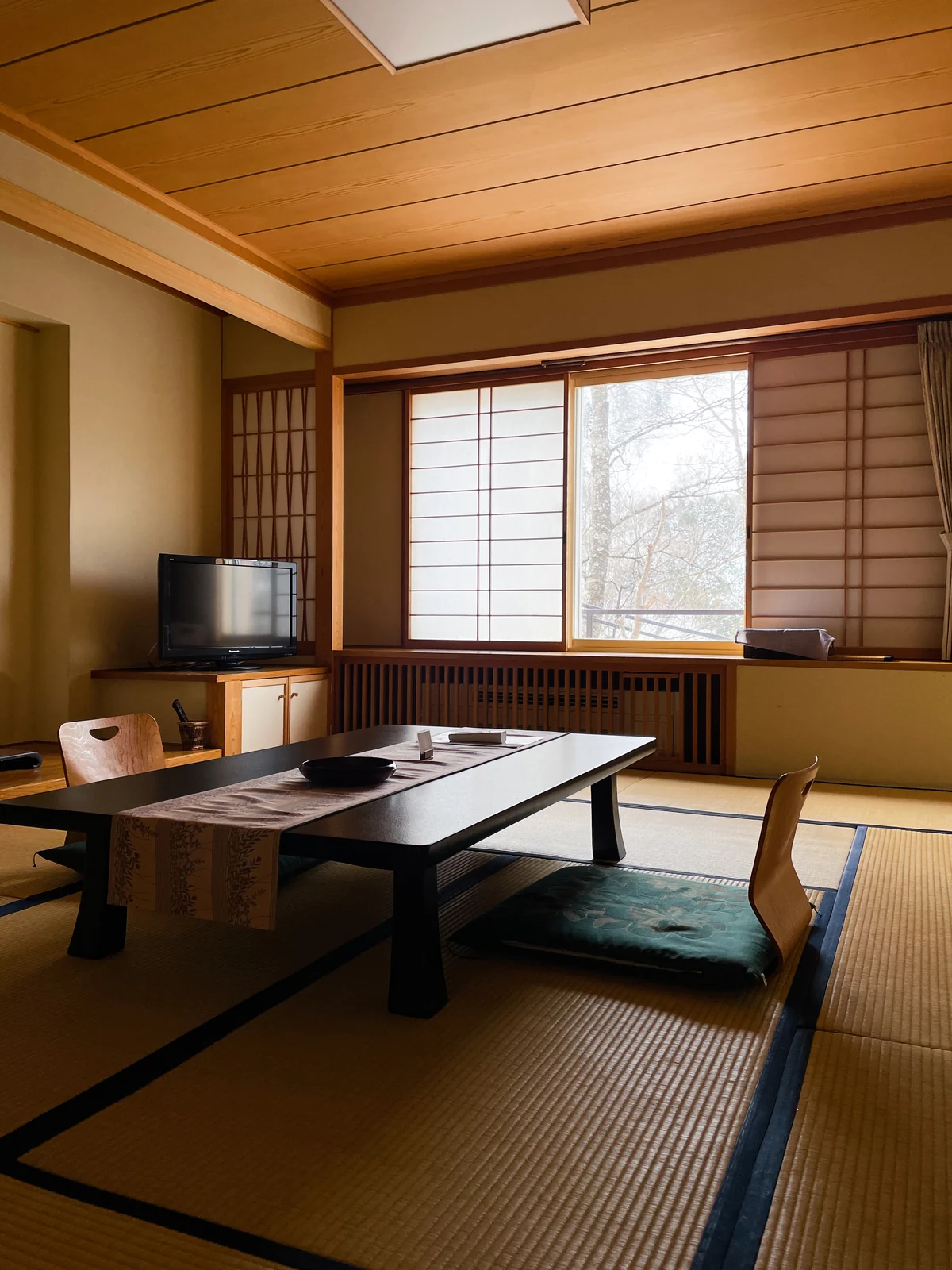 A traditional Japanese room with tatami flooring and low seating. Illustrative interior, not a named property.